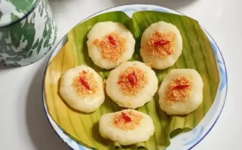 Adonan singkong oli jepret di atas piring, dengan toping taburan serundeng dan irisan cabai.