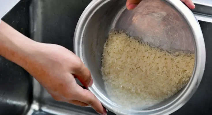 Mencuci beras dan menuangkan air cucian beras