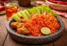 Ayam geprek dan sambal yang sangat pedas serta lalapan dalam wadah cobek batu.