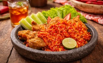 Ayam geprek dan sambal yang sangat pedas serta lalapan dalam wadah cobek batu.