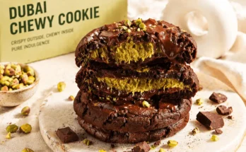 Tiga susun cokelat Dubai atau Dubai Chewy Cookie berbentuk bulat seperti donat yang sudah digigit memperlihatkan isian di dalamnya.