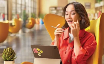 Seorang perempuan pekerja sedang bekerja di kafe dan memperhatikan layar tablet