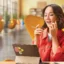 Seorang perempuan pekerja sedang bekerja di kafe dan memperhatikan layar tablet