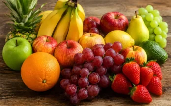 Buah buahan di atas meja. Pisang, apel, jeruk, anggur, pir, nanas, alpukat